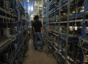 A large mining farm showcasing rows of mining rigs, highlighting the scale of some Bitcoin mining operations.